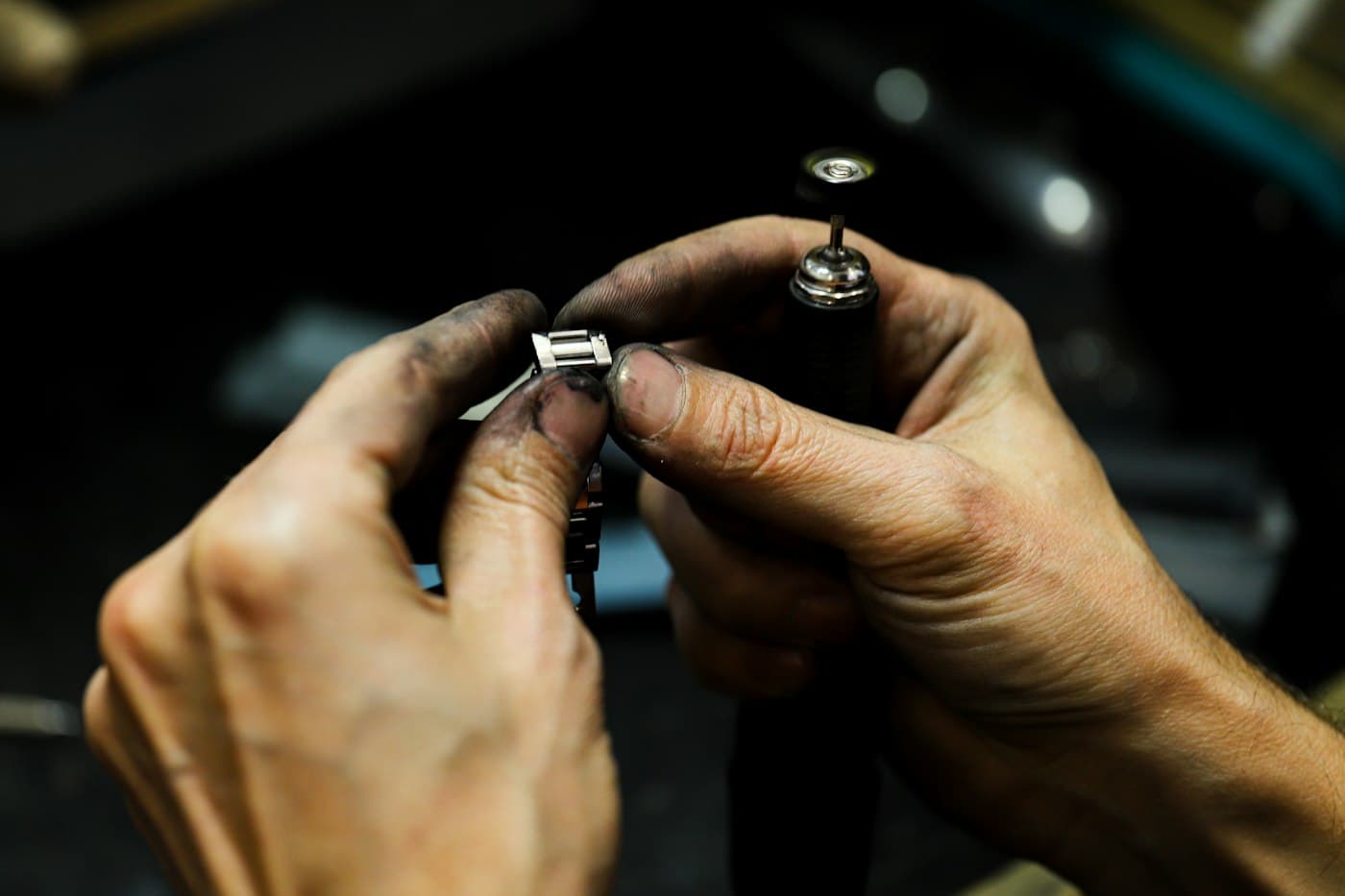 A jeweler’s hands setting a stone at the bench