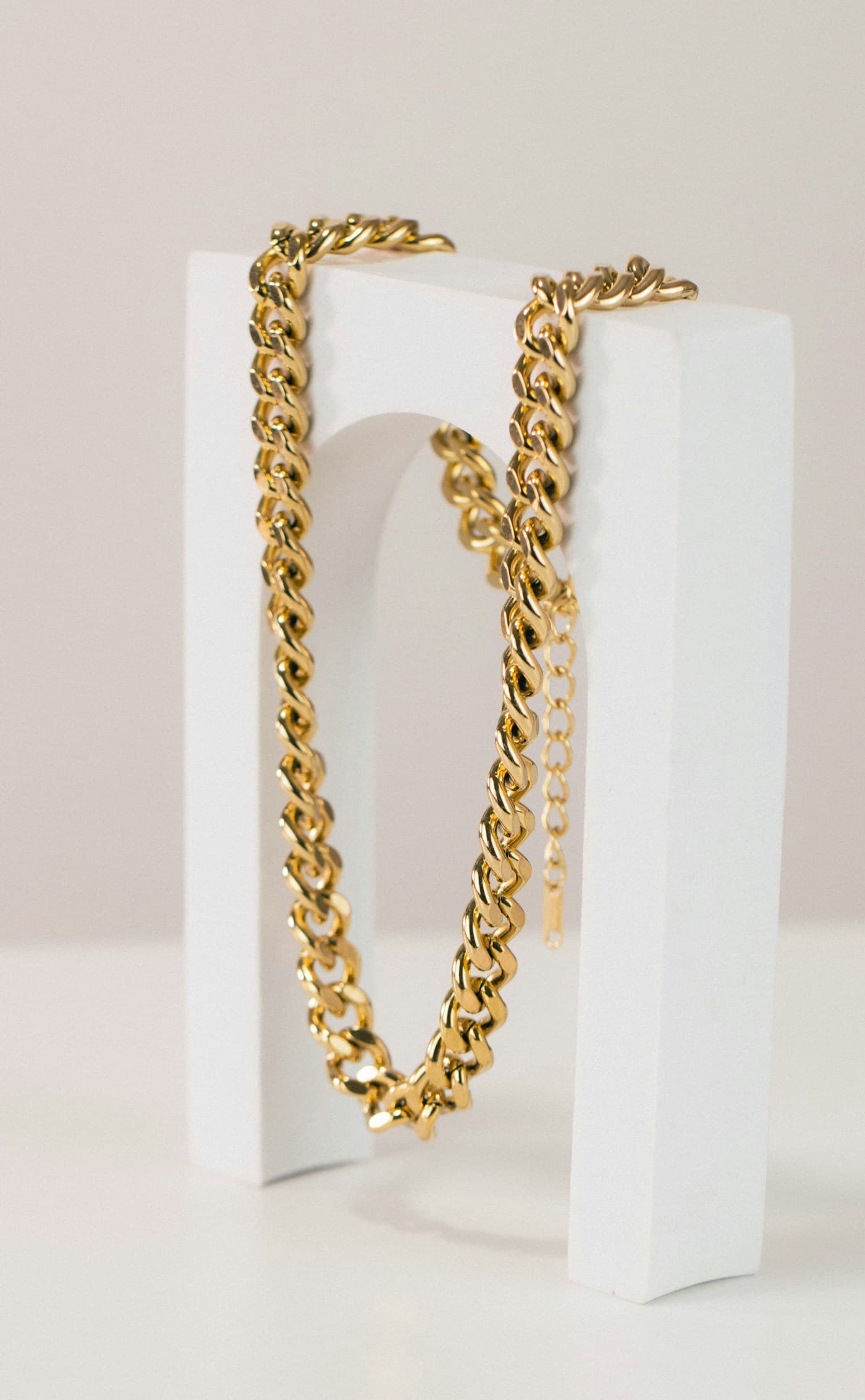 Gold Cuban link chain on a white display stand