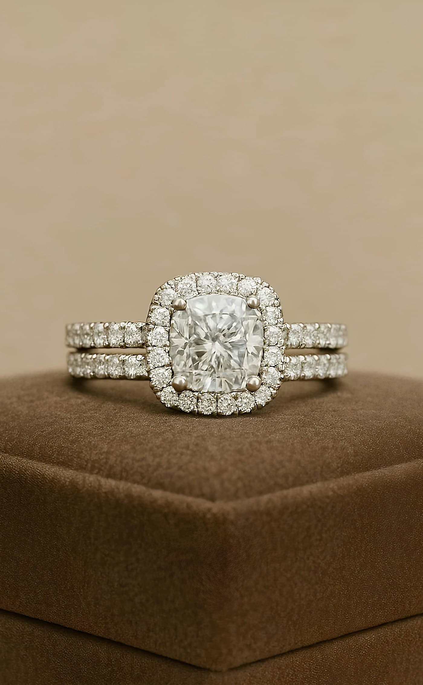 Cushion halo engagement ring with a pavé band on a display box